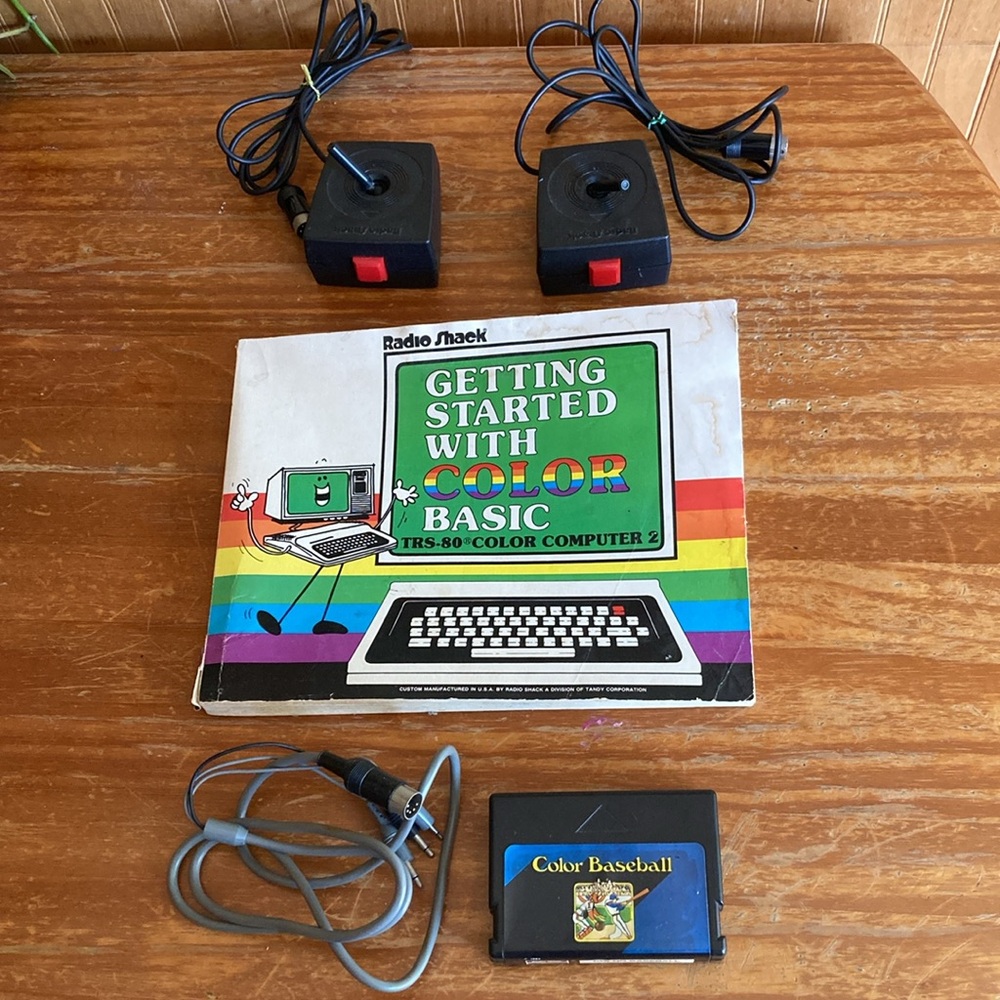 Radio Shack TRS-80 joysticks, game cable, game cartridge and Color Basic manual